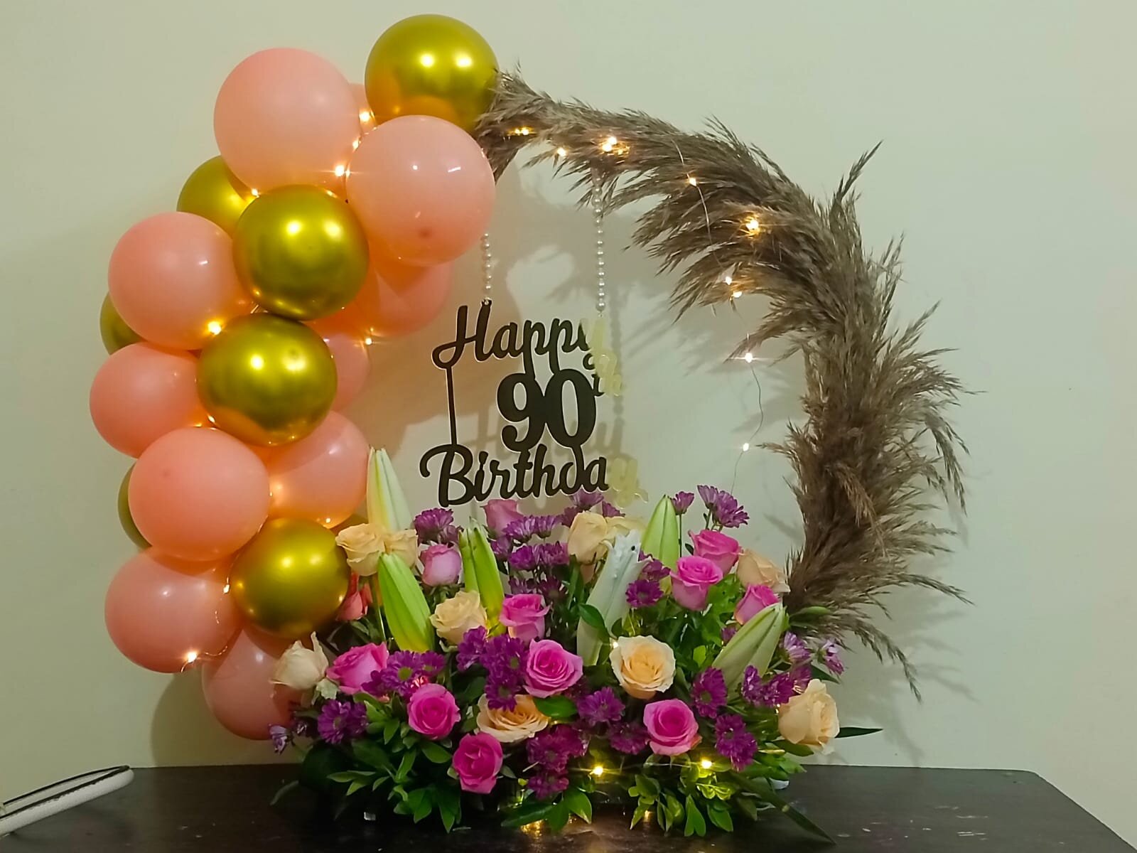 Birthday celebration with pink flowers and golden balloons