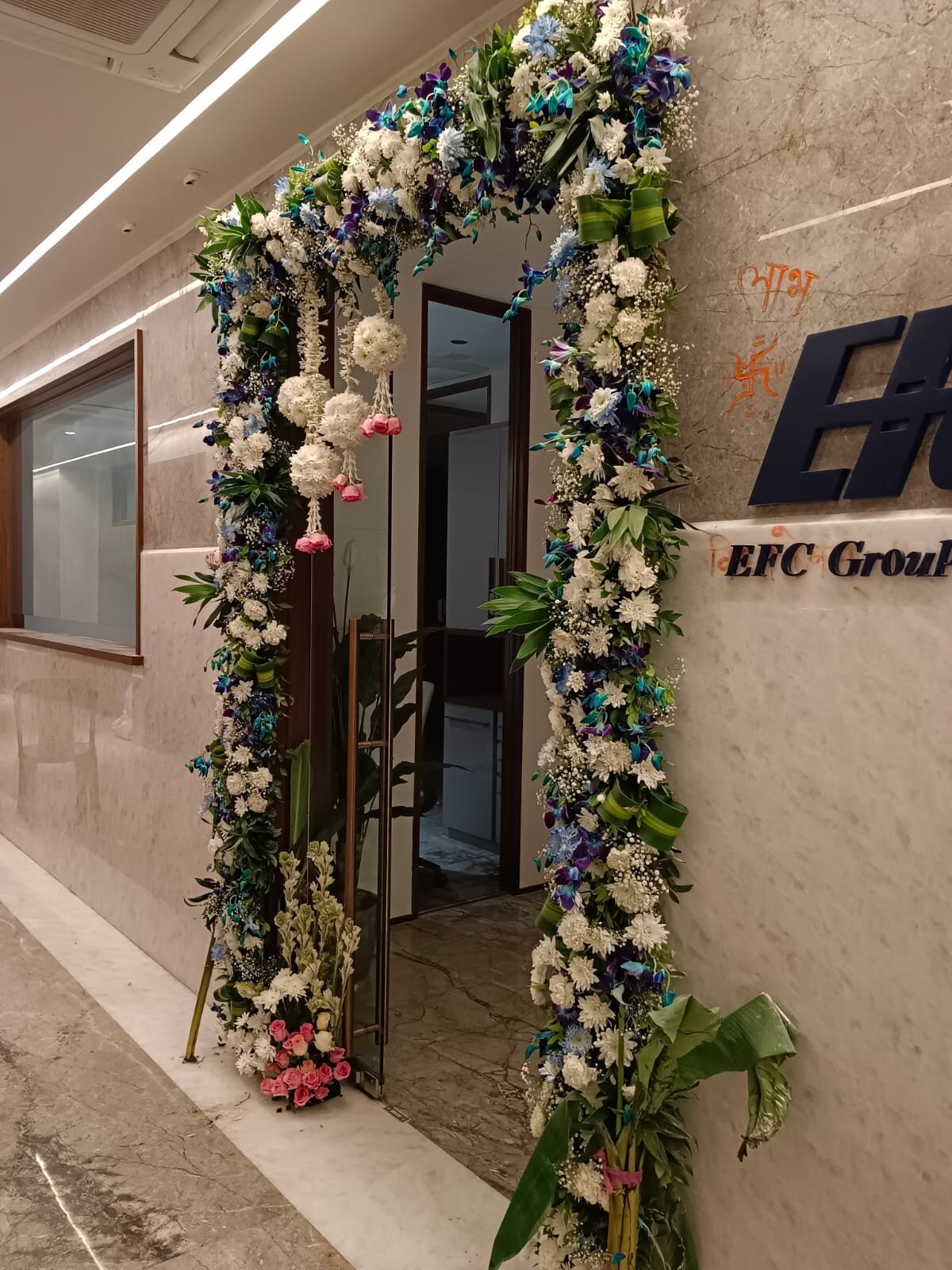 EFC Group office floral arch with white chrysanthemums and blue orchids