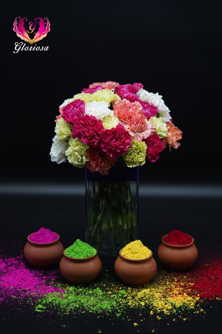 Colorful Holi-themed carnation bouquet with gulal pots
